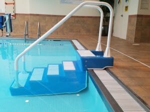 ADA Easy Stair with handrail installed at the edge of an indoor pool
